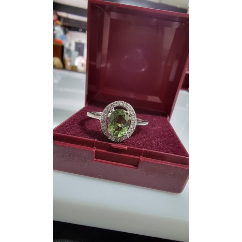 246 - Pretty 925 Silver dress ring inset with a large oval green crystal CZ stone surrounded by white Topa... 