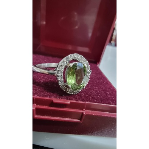 246 - Pretty 925 Silver dress ring inset with a large oval green crystal CZ stone surrounded by white Topa... 