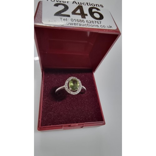 246 - Pretty 925 Silver dress ring inset with a large oval green crystal CZ stone surrounded by white Topa... 