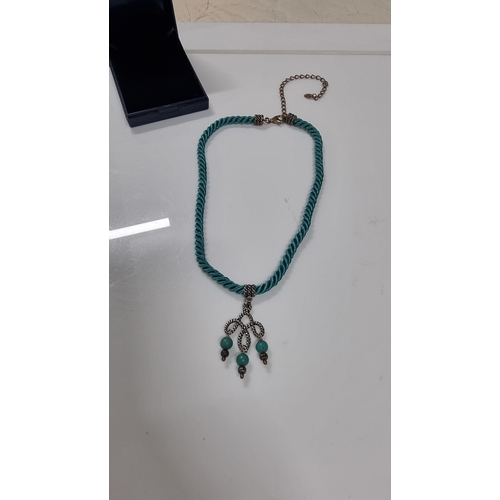 271 - 925 silver pendant with Turquoise bead drops on blue rope cord. With silver mounts & clasp to the en... 