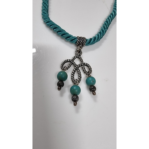 271 - 925 silver pendant with Turquoise bead drops on blue rope cord. With silver mounts & clasp to the en... 