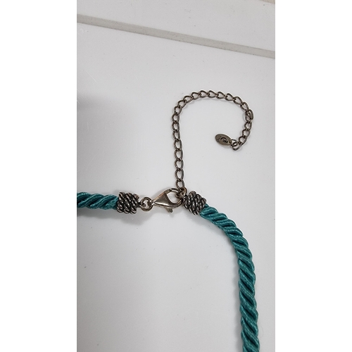 271 - 925 silver pendant with Turquoise bead drops on blue rope cord. With silver mounts & clasp to the en... 