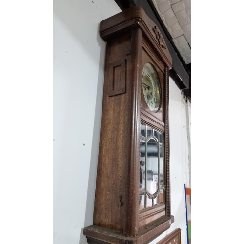 67 - Antique solid oak wall clock with a bevel edged glass door front in good condition striking on a gon... 