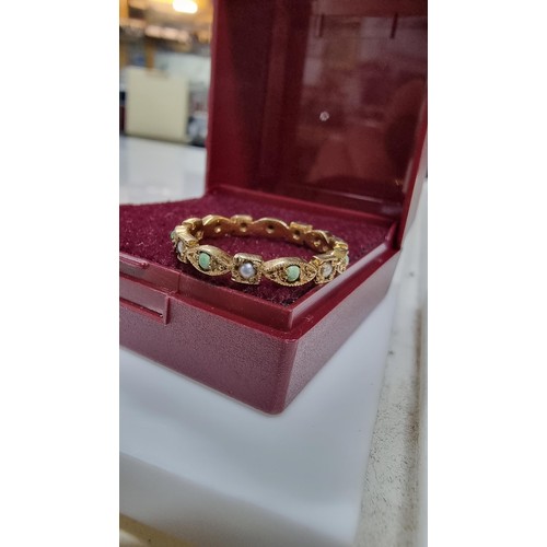 317 - Unusual hallmarked 9ct gold ring inset with small split seed pearls and green stones in good conditi... 