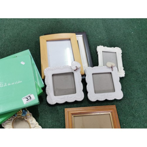 33 - Large quantity of small picture frames three are new in box, inc enamel frames etc largest stands at... 