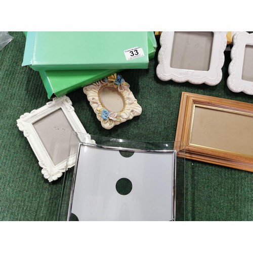 33 - Large quantity of small picture frames three are new in box, inc enamel frames etc largest stands at... 