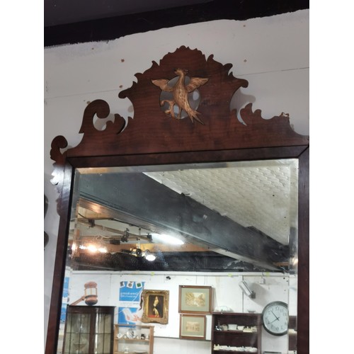 65 - Antique bevel edged mirror with ornate wooden surround and phoenix in centre, in need of restoration... 