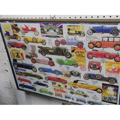 199 - Framed and glazed jigsaw puzzle depicting vintage cars. Height 50cm x 71cm.