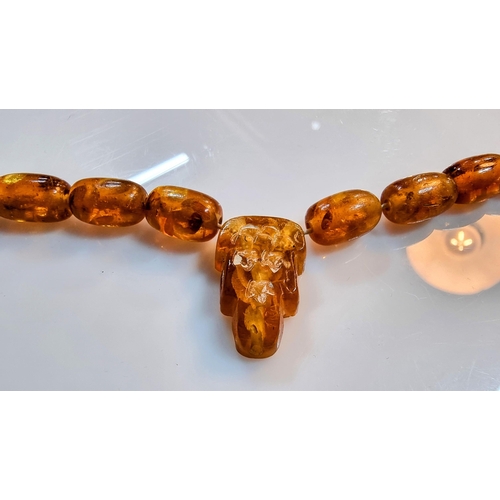 284 - Unusual vintage genuine baltic amber beaded necklace with inclusions with a face, skull carved penda... 