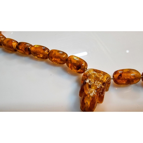 284 - Unusual vintage genuine baltic amber beaded necklace with inclusions with a face, skull carved penda... 