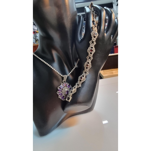 290 - Ornate 925 silver pendant with a striking design inset with a quantity of purple CZ stones & marcasi... 