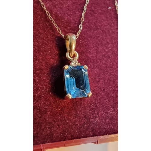 314 - 9ct. gold pendant inset with large cushion cut blue aquamarine stone set on a 18