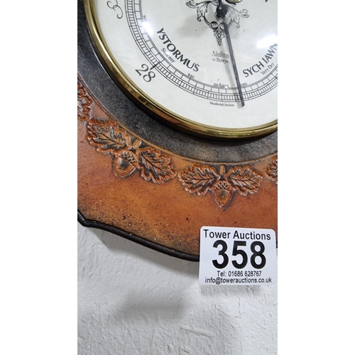 358 - Leather framed Welsh barometer with an embossed acorn design. Dial is in Welsh & English made by Ala... 