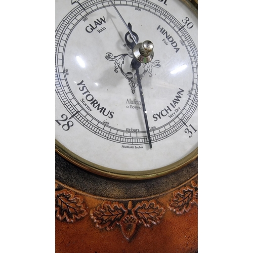 358 - Leather framed Welsh barometer with an embossed acorn design. Dial is in Welsh & English made by Ala... 