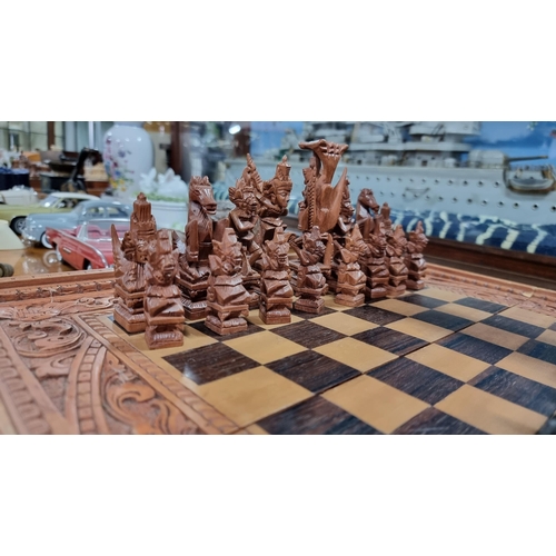 366 - Good quality Balinese Indonesian wooden hand carved deity chess set with intricately hand carved fig... 