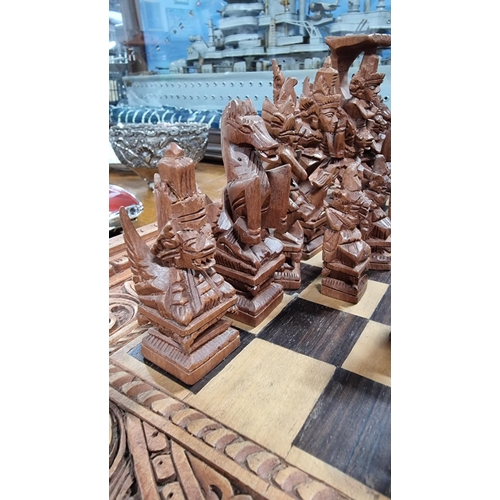 366 - Good quality Balinese Indonesian wooden hand carved deity chess set with intricately hand carved fig... 