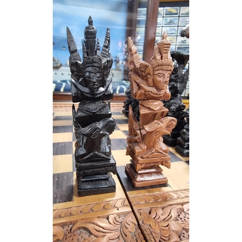 366 - Good quality Balinese Indonesian wooden hand carved deity chess set with intricately hand carved fig... 