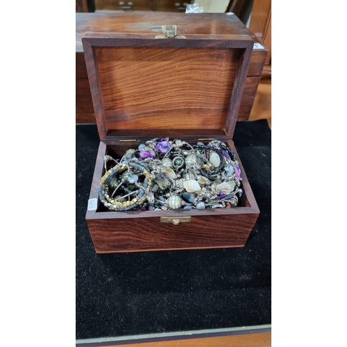 384 - Mahogany wooden box with brass butterflies to the top complete with a quantity of costume jewellery.... 