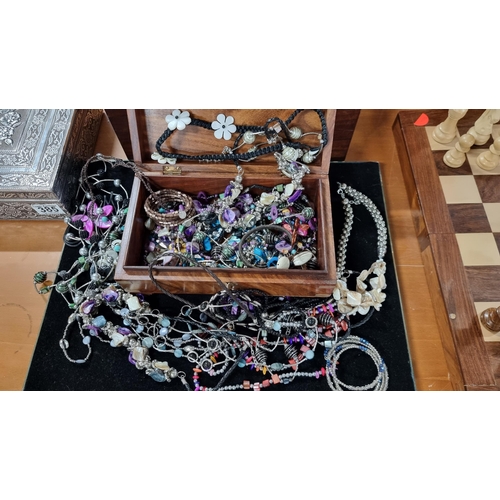 386 - Solid Mahogany box with brass mounts complete with a large quantity of costume jewellery. Height 9.5... 