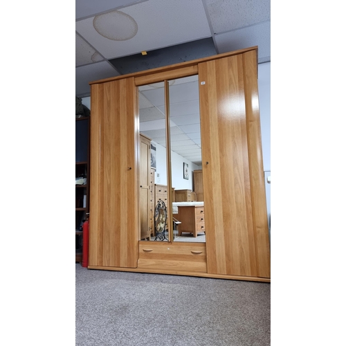 484 - Good quality modern French oak effect large triple wardrobe with two mirrored doors to the centre & ... 