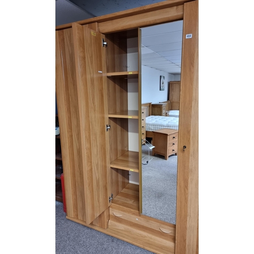 484 - Good quality modern French oak effect large triple wardrobe with two mirrored doors to the centre & ... 