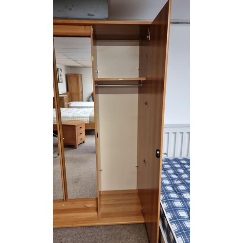 484 - Good quality modern French oak effect large triple wardrobe with two mirrored doors to the centre & ... 