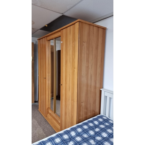 484 - Good quality modern French oak effect large triple wardrobe with two mirrored doors to the centre & ... 