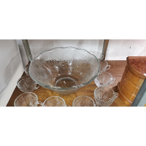 123 - Large Thick glass Punch bowl with a quantity of 9x thick glass cups has a decorative floral design a... 