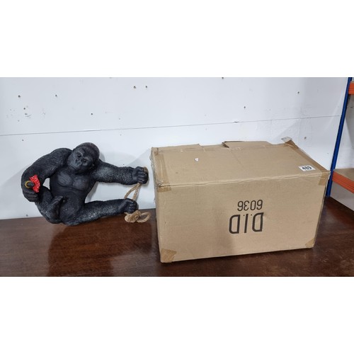 489 - Boxed as new large resin hanging Gorilla figure with a flower ring height 32cm, length 40cm width 20... 