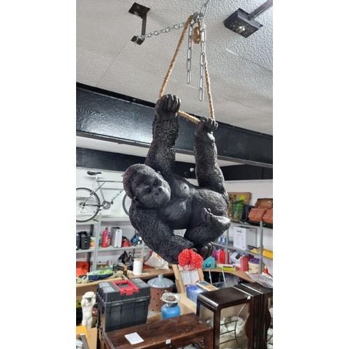 489 - Boxed as new large resin hanging Gorilla figure with a flower ring height 32cm, length 40cm width 20... 