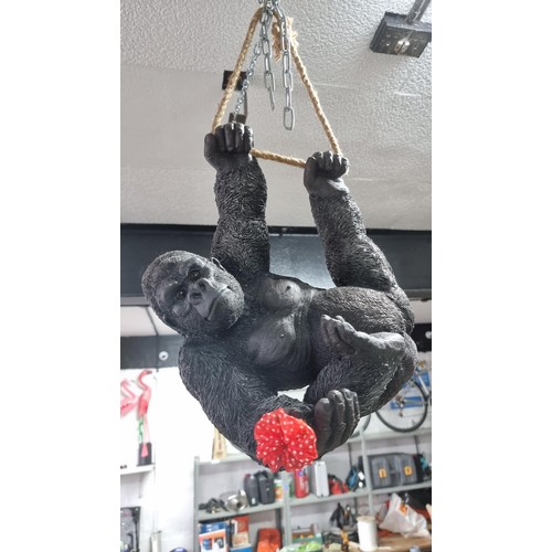 489 - Boxed as new large resin hanging Gorilla figure with a flower ring height 32cm, length 40cm width 20... 