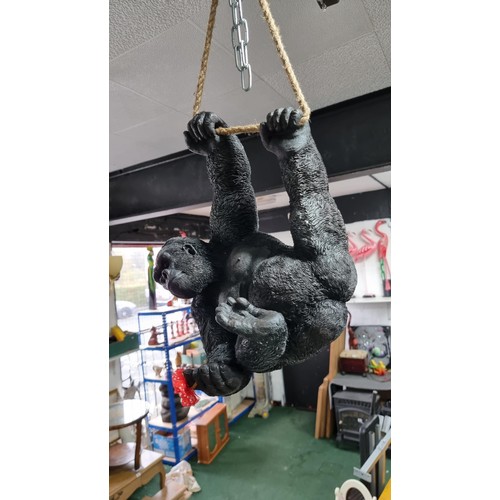 489 - Boxed as new large resin hanging Gorilla figure with a flower ring height 32cm, length 40cm width 20... 