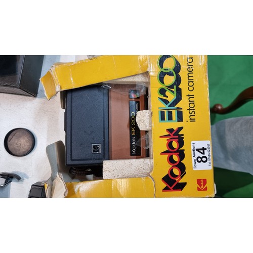 84 - Quantity of various cameras Topcon 35mm camera and 55mm lens, a Kodak EK200 instant camera, flashes ... 