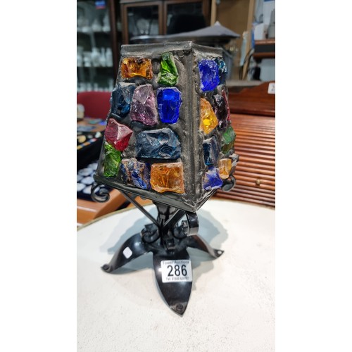 286 - Unusual iron table lamp with multi coloured glass faceted rock shade displays well when lit up  in g... 