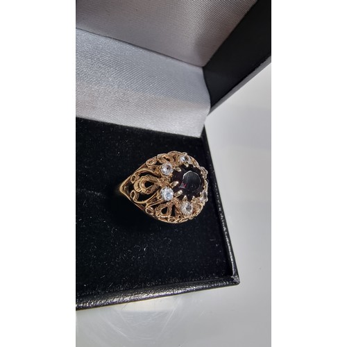 369 - hallmarked yellow gold ornate dress ring inset with a large garnet stone to the centre surrounded by... 