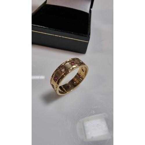 370 - Hallmarked yellow gold eternity ring inset with ruby stones and white topaz stones all the way round... 