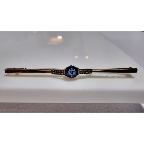 371 - 9ct gold and silver bar brooch inset with a pretty blue glass stone to the centre and white clear st... 