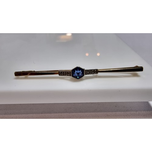 371 - 9ct gold and silver bar brooch inset with a pretty blue glass stone to the centre and white clear st... 