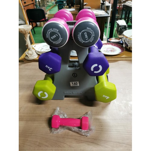 140 - Set of weight training dumbells on stand 1.5kg, 3kg, 4kg weights. In very good condition.