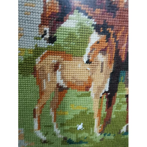 202 - Framed & glazed embroidery of horses in the wild & swans on a lake. 54cm width, 37cm height.