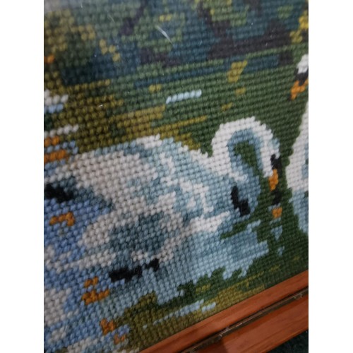 202 - Framed & glazed embroidery of horses in the wild & swans on a lake. 54cm width, 37cm height.