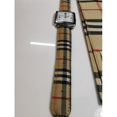 318 - Unused unisex burberry quartz watch with a chrome bezel in its original taran case with tartan strap... 