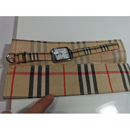 318 - Unused unisex burberry quartz watch with a chrome bezel in its original taran case with tartan strap... 