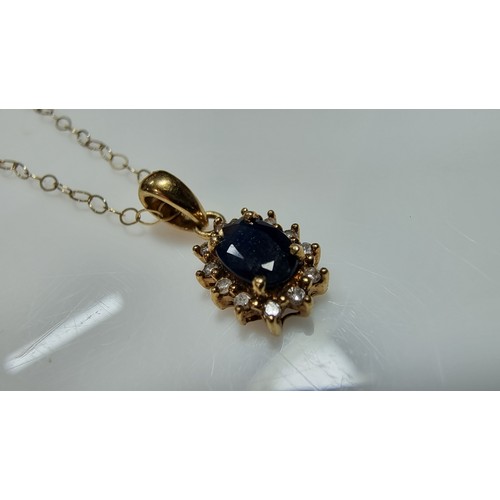 382 - 9ct yellow gold pendant and 16in chain and matching earrings, pendant is inset with dark blue sapphi... 