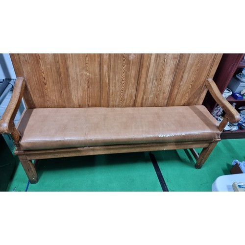 490 - Antique pitch pine settle with a paneled back inc a fitted upholstered cushion in good overall condi... 