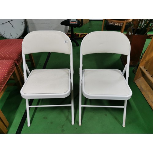 483 - 2x folding indoor/ outdoor white metal chairs with leatherette seat & back.