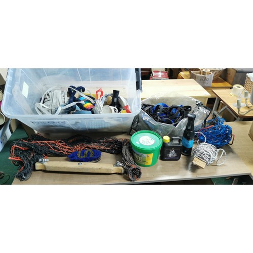 132 - Large box with electric fence tape, bridal parts,stirrup treads, reins,head collars, lead reins, hay... 