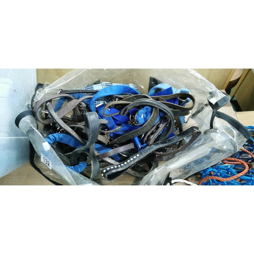 132 - Large box with electric fence tape, bridal parts,stirrup treads, reins,head collars, lead reins, hay... 