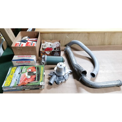 172 - Car parts including a new water pump and exhaust pipes and a fuel filter and some classic car mags, ... 