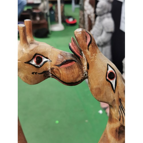 247 - Pair of tall wooden nuzzling giraffes, old repair to the head. Measures 80cm height x 28cm long x 8c... 